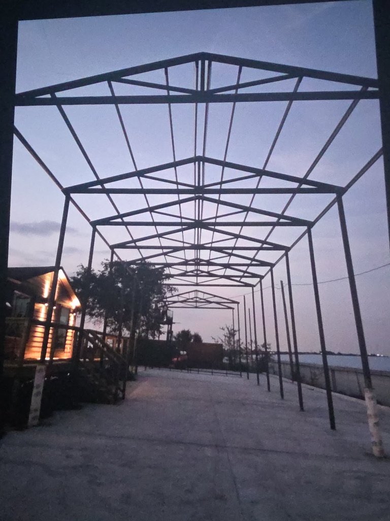 The KJM Stones stone slab showroom Buda TX yard at dusk, with the new steel structure going up