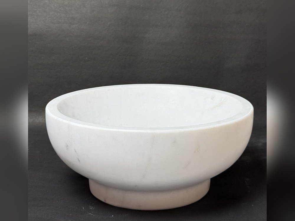 White marble footed bowl, hand-carved, on a dark slate surface