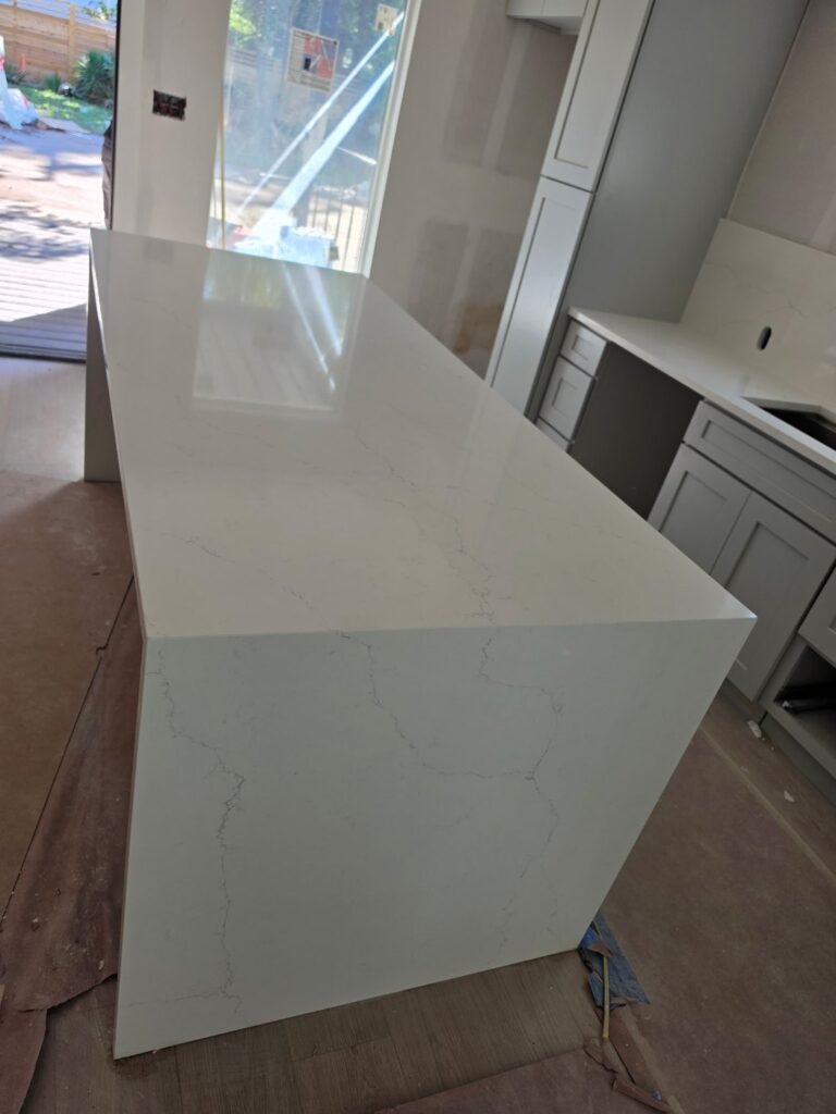 Calacatta Riviera quartz island seen along its length, showing the waterfall edge