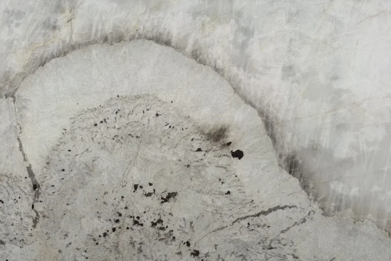 Patagonia Crystal quartzite slab — white crystalline stone with a dramatic grey halo vein and dark garnet accents, in stock at KJM Stones in Buda, TX