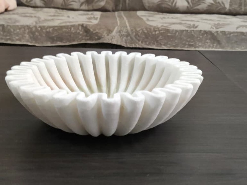 Hand-carved white marble ridge-fluted bowl on a dark table, a KJM Stones stone craft