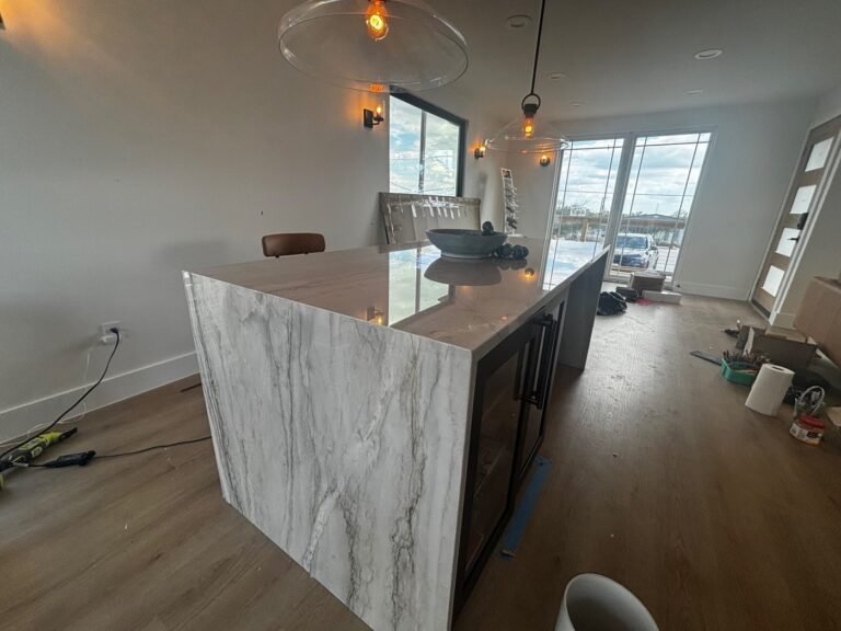 Mykonos quartzite bar counter with a waterfall end beside a built-in wine fridge